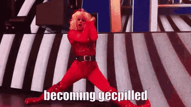 a woman in a red outfit is dancing on a stage with the words `` becoming gecpilled '' written on the bottom .