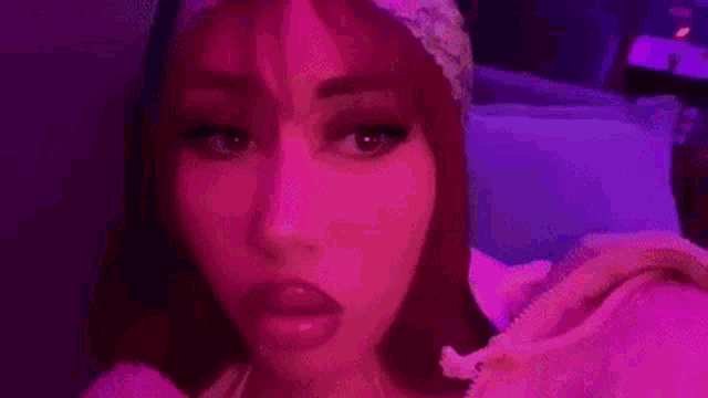 a close up of a woman 's face with purple lights on .
