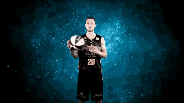a man in a black jersey with the number 20 holds a basketball