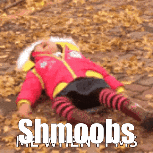 a child is laying on the ground with the words shmoobs written above her