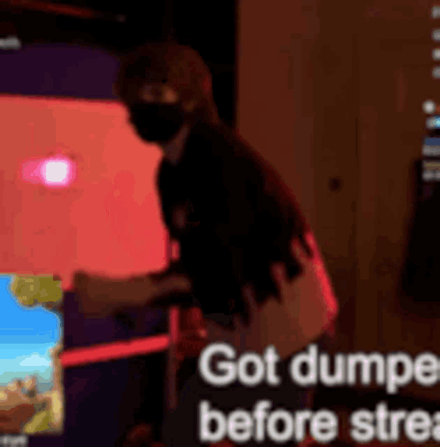 a man wearing a mask is standing in front of a screen that says " got dumped before stre "