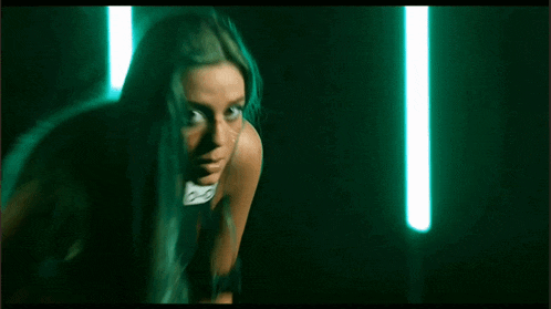 a woman with blue hair is looking at the camera