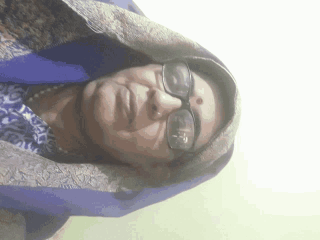 a woman wearing glasses and a blue scarf