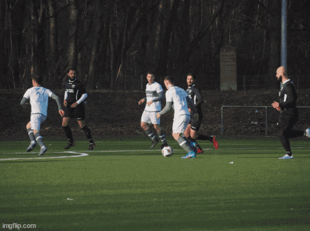 a group of soccer players are playing on a field with a scoreboard that says gast on it