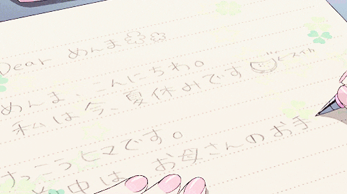 a person writing on a piece of paper with chinese writing