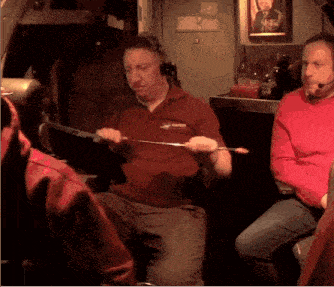 a man wearing a red shirt that says safety holds a stick