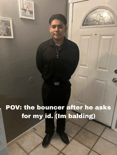 a man in a black shirt stands in front of a white door