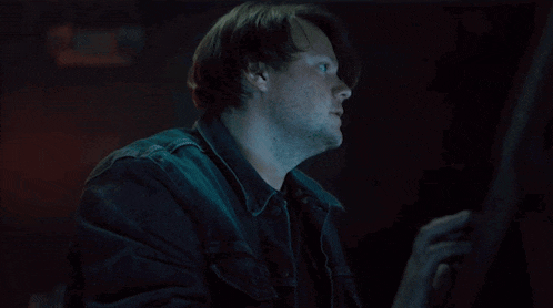 a man in a denim jacket is looking up at something