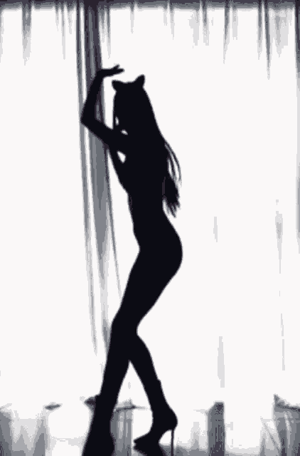 a silhouette of a woman with cat ears is dancing