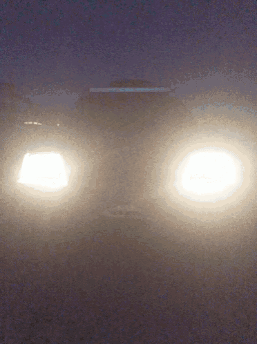 a car 's headlights are lit up in the fog