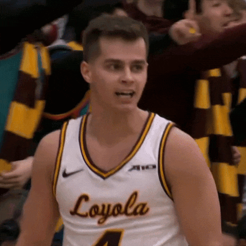 a man wearing a loyola jersey stands in front of a crowd of people