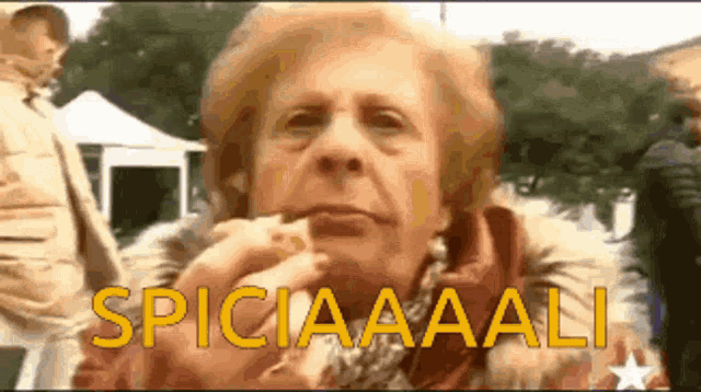 an older woman eating a sandwich with the words spicia aaali written in yellow letters