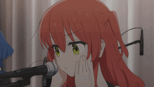 a girl with red hair and green eyes looks at a microphone