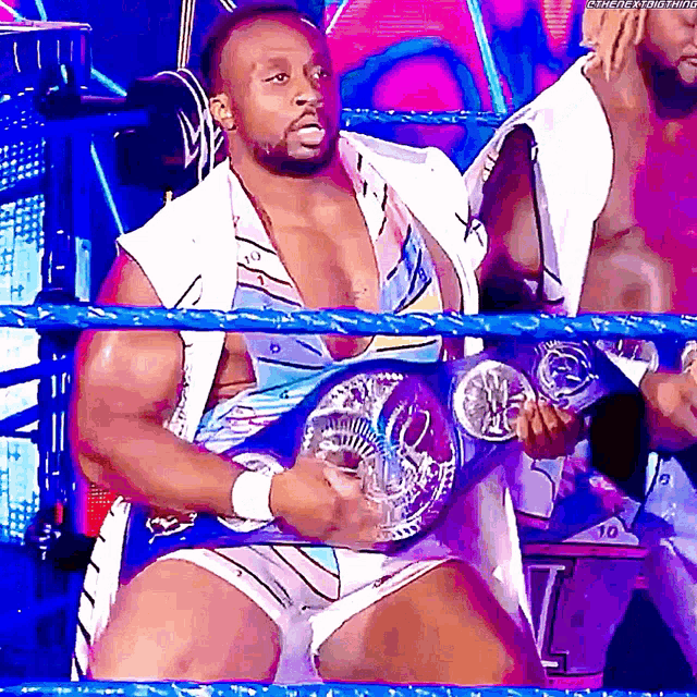 a man in a wrestling ring holding a championship belt that says ' smackdown ' on it