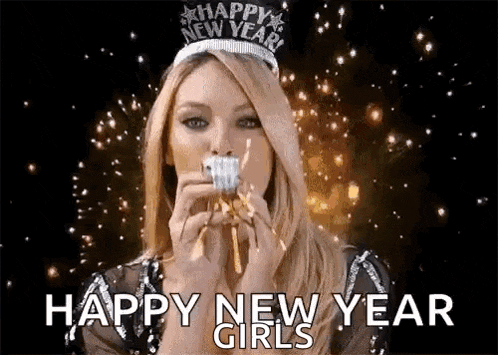 a woman wearing a new year 's eve tiara is blowing a party horn while eating a cupcake .