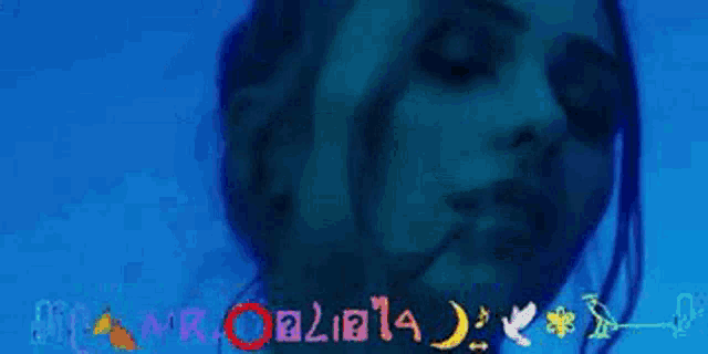 a woman is smoking a cigarette in a dark room with a blue background that says ' cannabis ' on it