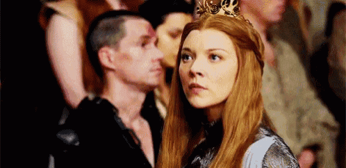 a woman wearing a crown is standing in front of a crowd of people .