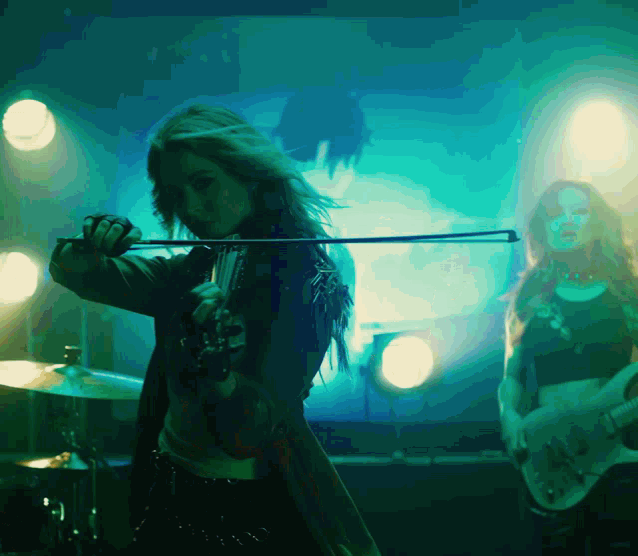 a woman playing a violin and a woman playing a guitar