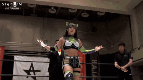 a female wrestler stands in a ring with a stardom banner in the background