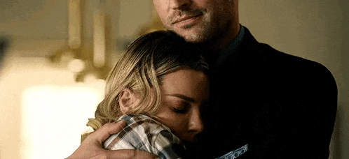 a man and a woman are hugging each other in a room .