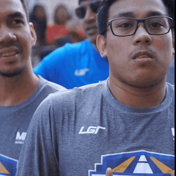 a man wearing glasses and a gray shirt with the letters lgr on it