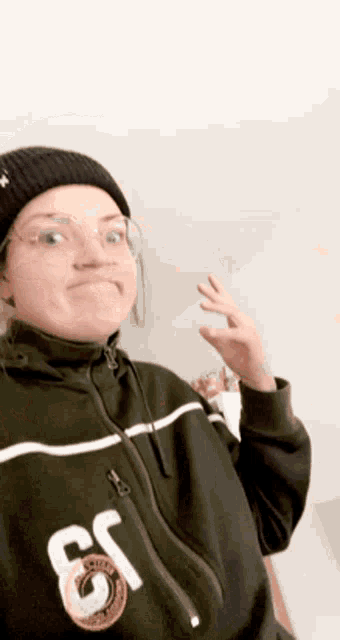 a woman wearing a beanie and a sweatshirt with the number 61 on it