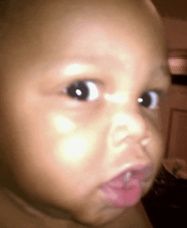 a close up of a baby 's face with a pink lip