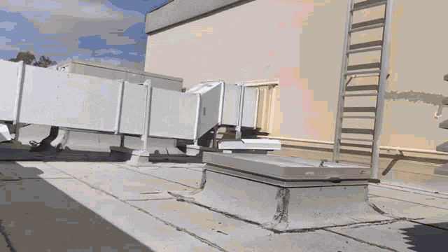 a ladder is attached to the side of a building next to a ventilation system