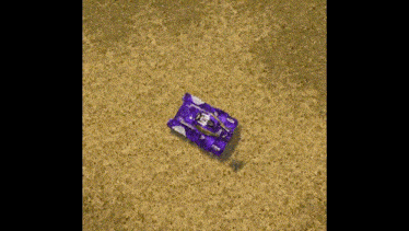 a purple tank is sitting on a sandy field