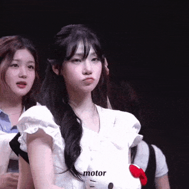 a girl in a white dress is holding a hello kitty toy