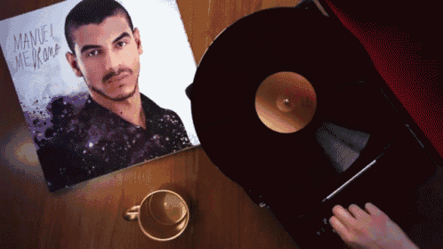 a person is playing a record on a turntable next to a picture of manuel me duran