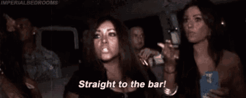 a woman is standing in a car with her arms in the air and shouting straight to the bar .