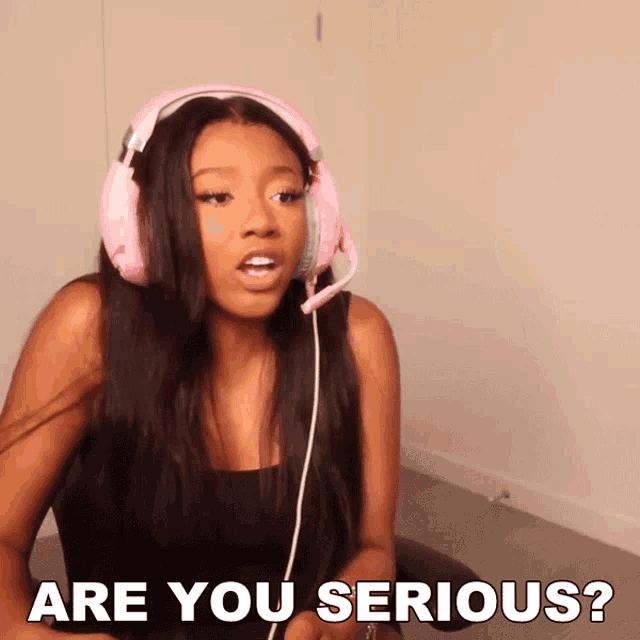 a woman wearing pink headphones and a black tank top says " are you serious "