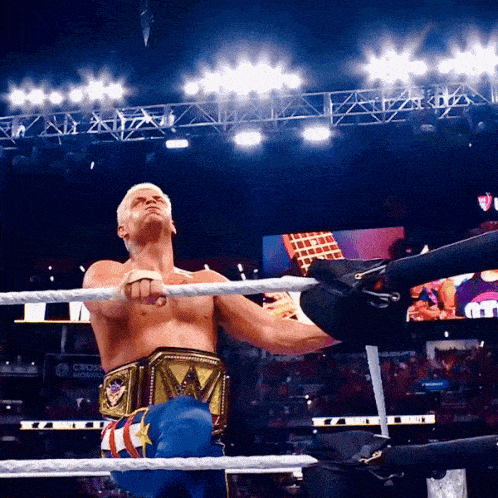 a man in a wrestling ring with a belt that says wwe on it