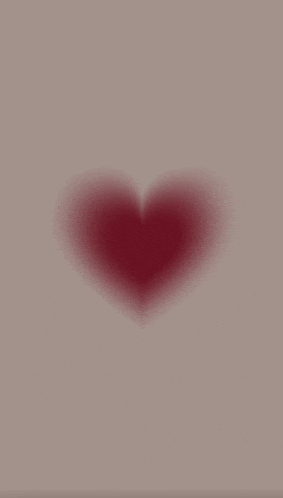 a blurred image of a red heart on a beige background .