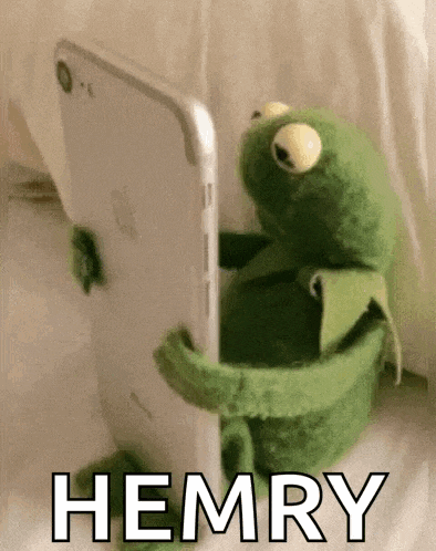 a kermit the frog is holding a cell phone with the word hemry written on it .