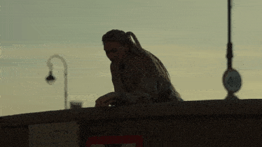 a woman leaning on a wall with a sign that says busto on it