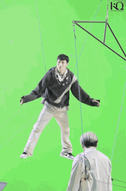 a man hanging from a rope with the letter k on the bottom