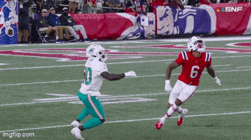 a football player with the number 6 on his jersey runs towards another player