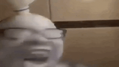a person wearing glasses and a bun is making a funny face .