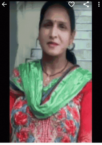 a woman is wearing a green scarf around her neck and a red and green dress .