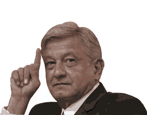a man in a suit and tie is making a silence gesture with his finger on his lips .