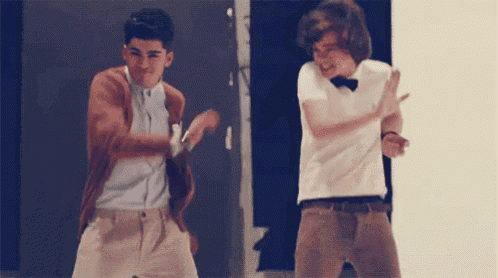 two young men are dancing together in a room . one of them is wearing a bow tie .