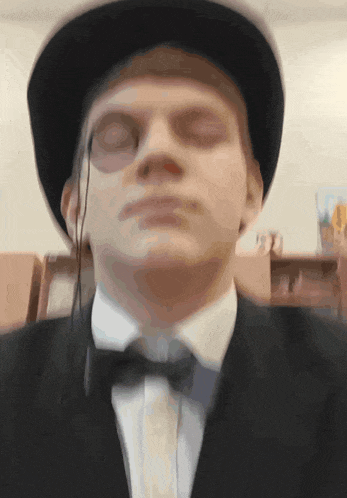 a man wearing a hat and a bow tie