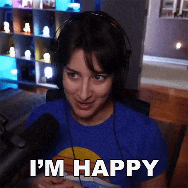 a woman wearing headphones says i 'm happy in front of a microphone
