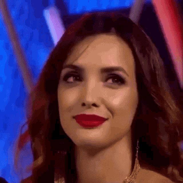 a close up of a woman wearing red lipstick and earrings .