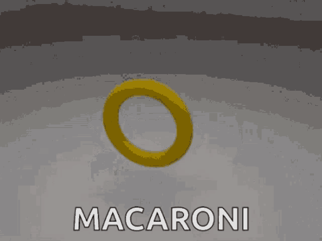 a yellow macaroni with two holes in it is sitting on a white surface .