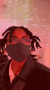 a man with dreadlocks wearing a nike mask