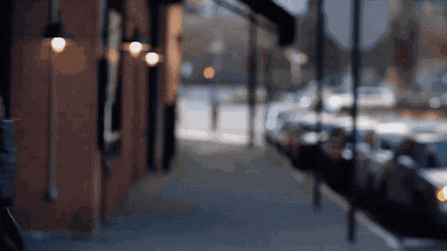 a blurry picture of a street with a brick building in the background