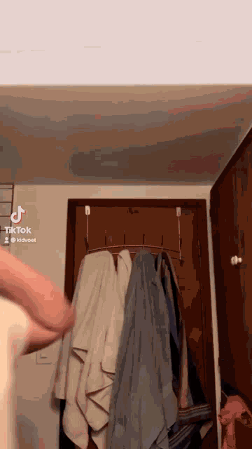 a person is standing in front of a closet with towels hanging on hooks